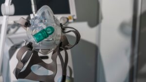 An anesthesia mask attached to a machine, used in ventilation and patient care settings.