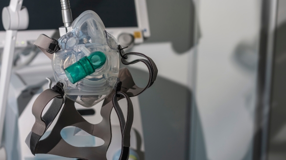 An anesthesia mask attached to a machine, used in ventilation and patient care settings.